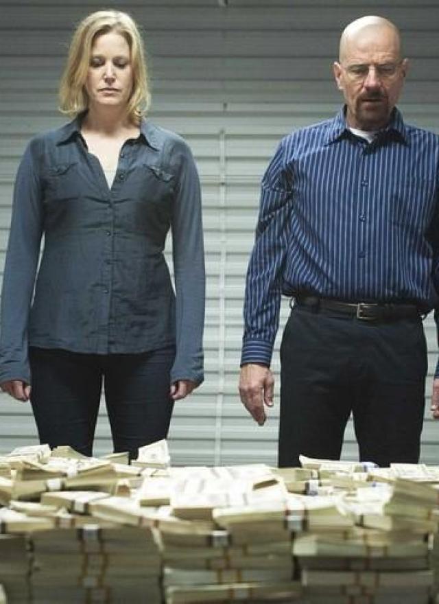 Walter White and his wife looking at a large pile of cash