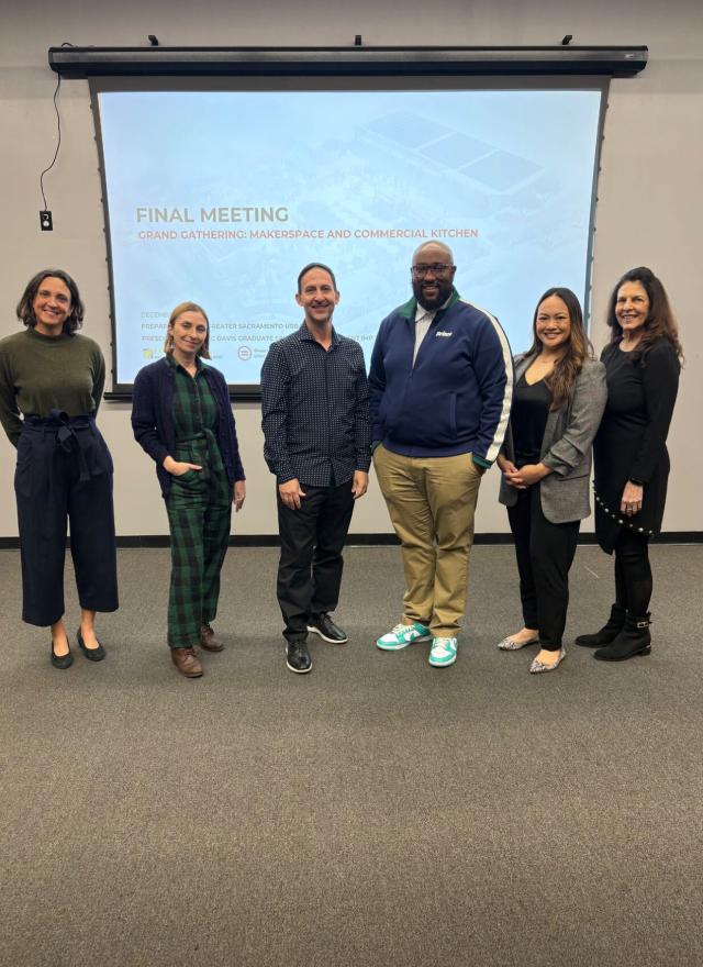 Liza Santa Ana and MBA students in front of a presentation screen