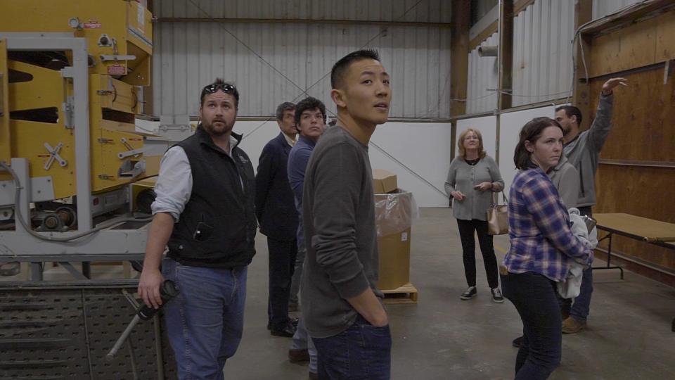 Yuan Cheng and MBA students inside a warehouse