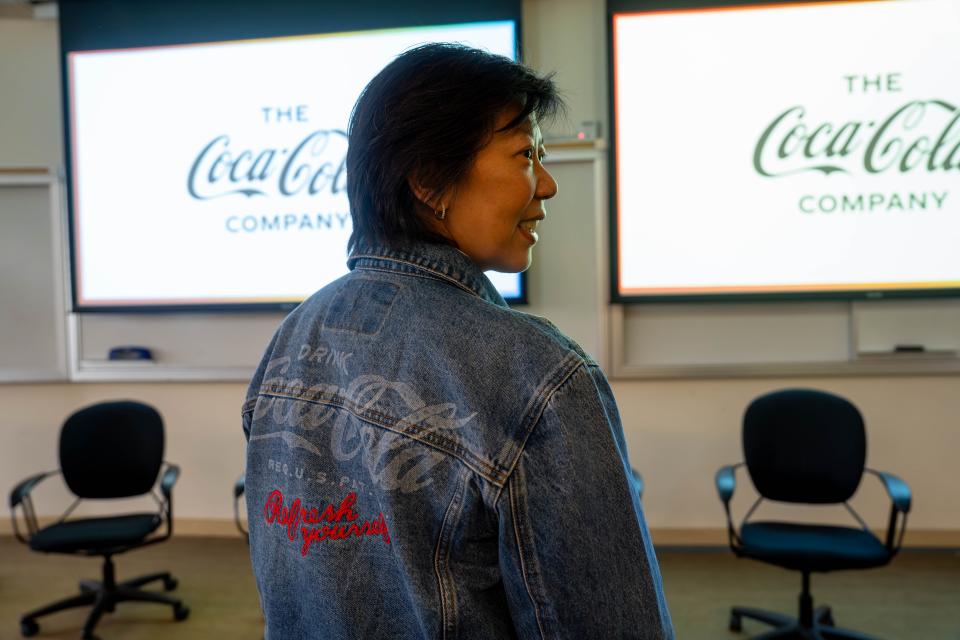 Woman wearing a denim jacket with a Coca Cola logo on the back