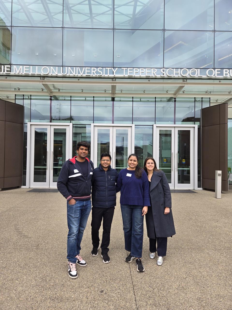 Four MBA students in front of Carnegie Mellon University